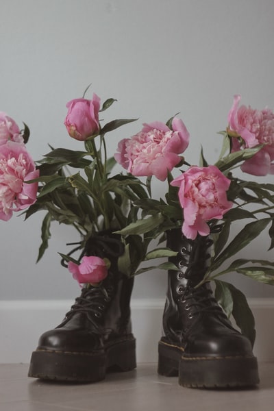 粉色的玫瑰在黑色的雨靴
